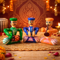 Three colorful figurines of musicians on a decorative background with lights and flowers.