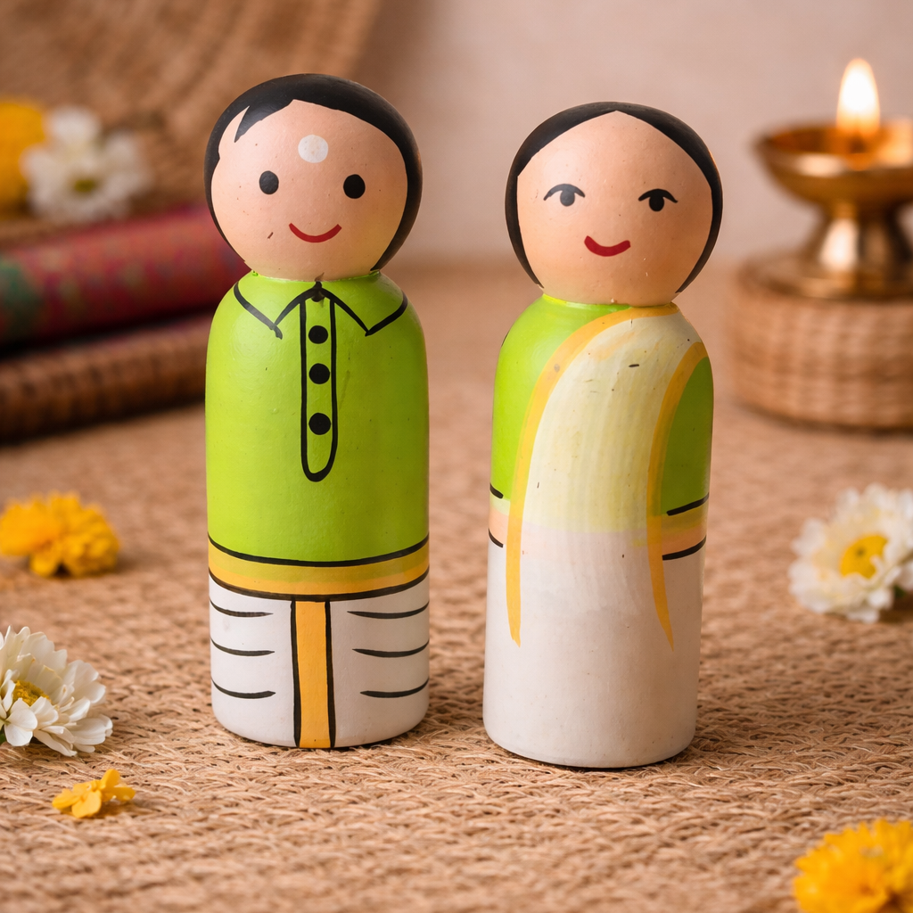 Two wooden peg dolls, one in green and one in white, on a textured surface with flowers and a candle in the background.