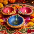 Decorative Diwali lamps with flowers on a colorful background